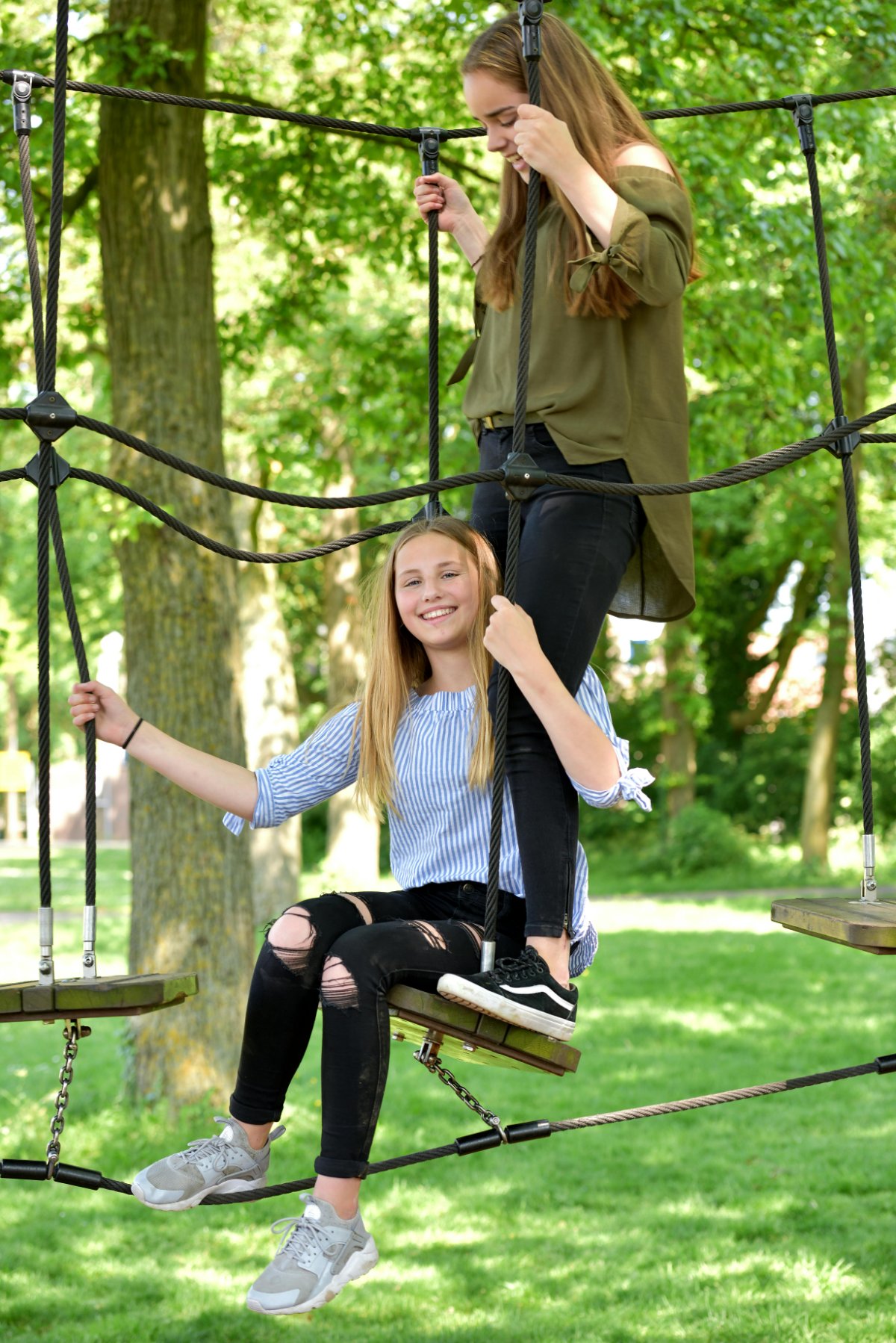 Twee meiden in een touwparcours in het park
